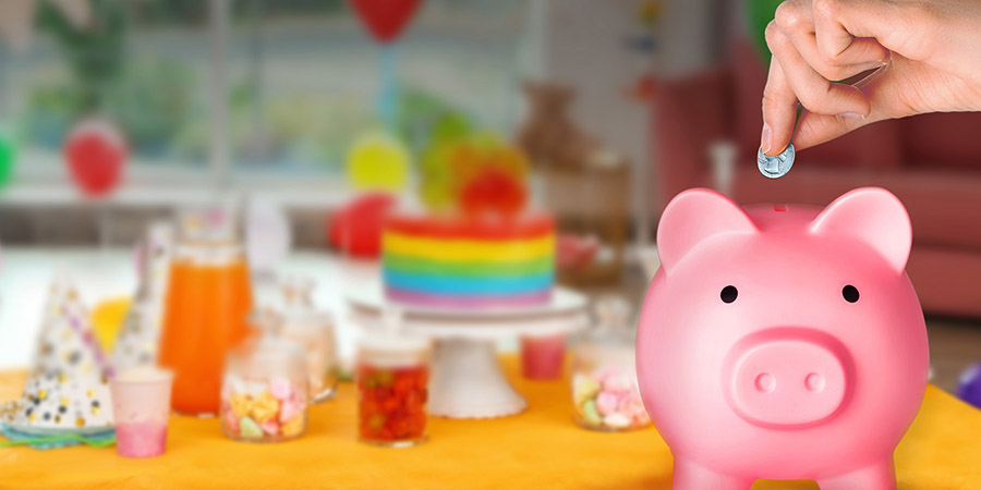 Bright birthday cake and other treats on table in decorated room